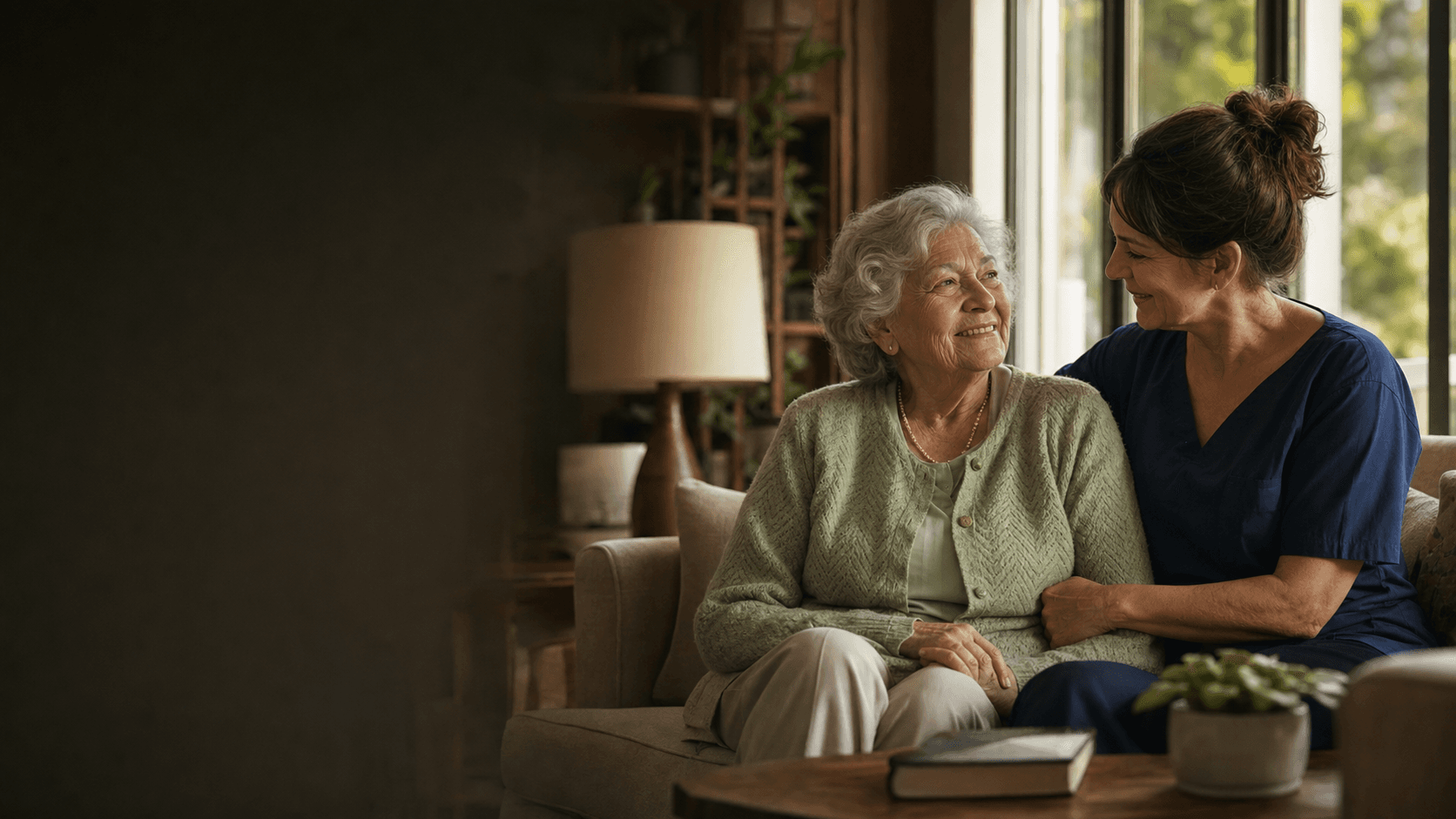 An assisted-living resident sharing a warm moment with a care professional.