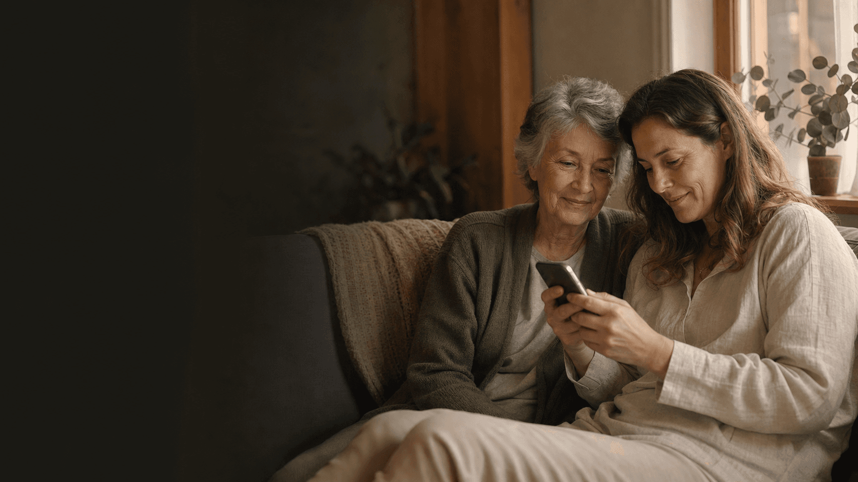 Grandmother smiling on the phone in a warm kitchen, afternoon light, flowers and a teacup on the table
