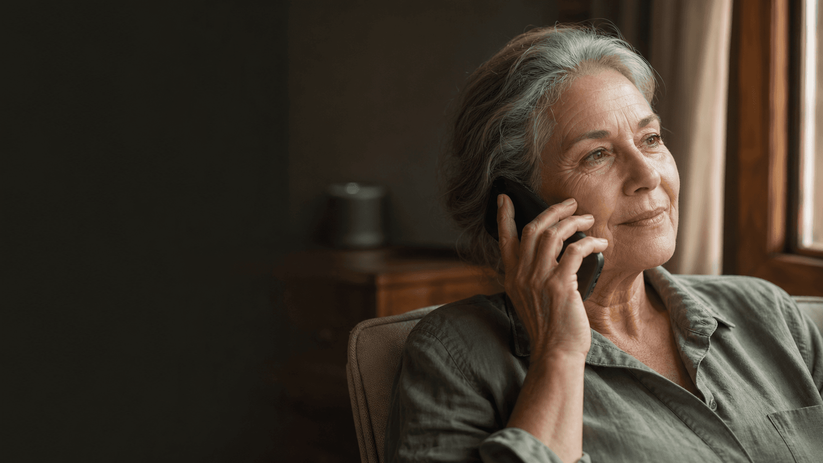 An older adult using dependable voice technology naturally at home.